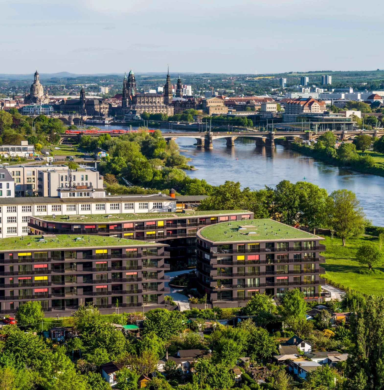 Luftaufnahme des Wohnprojekts Marina Garden in Dresden bei Sonnenuntergang mit der Elbe im Hintergrund